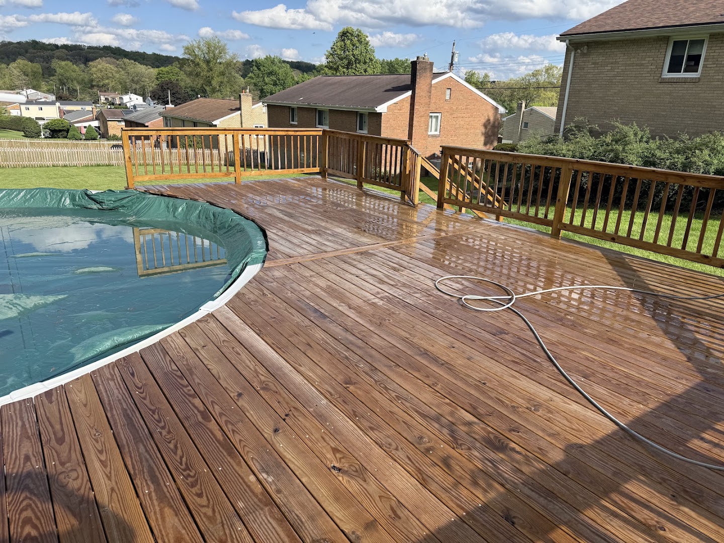 A wet, freshly cleaned wood pool deck glistening after a wash